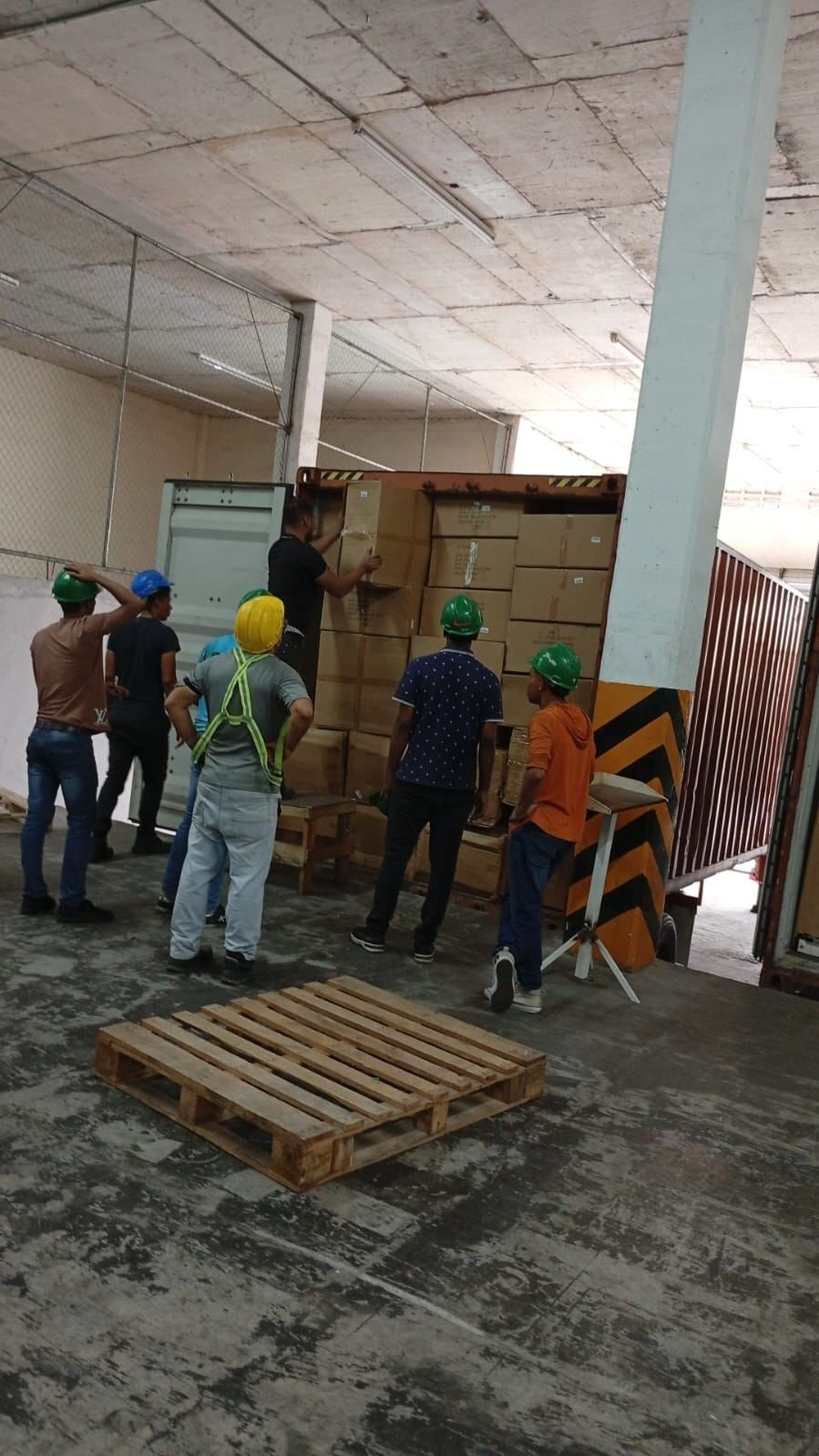 Personal descargando mercancía de un contenedor dentro de la bodega